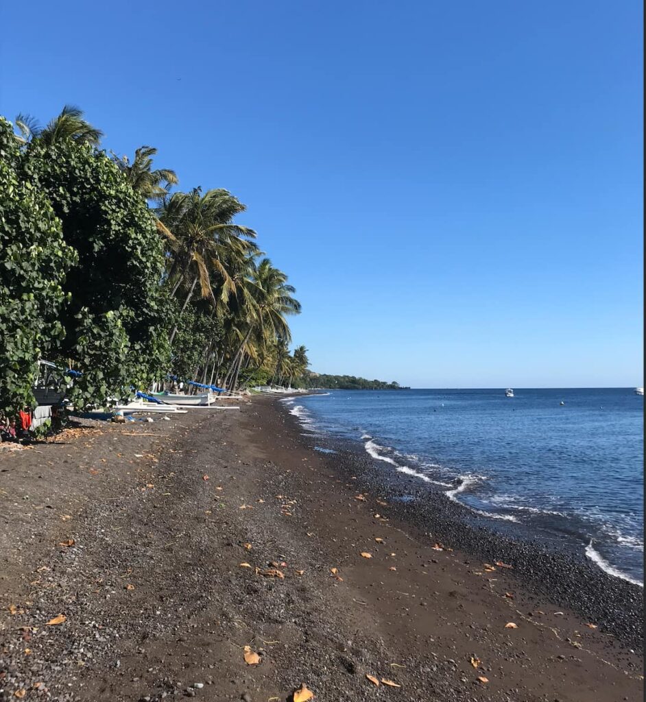 The black sand beach at macro point Seraya Secrets