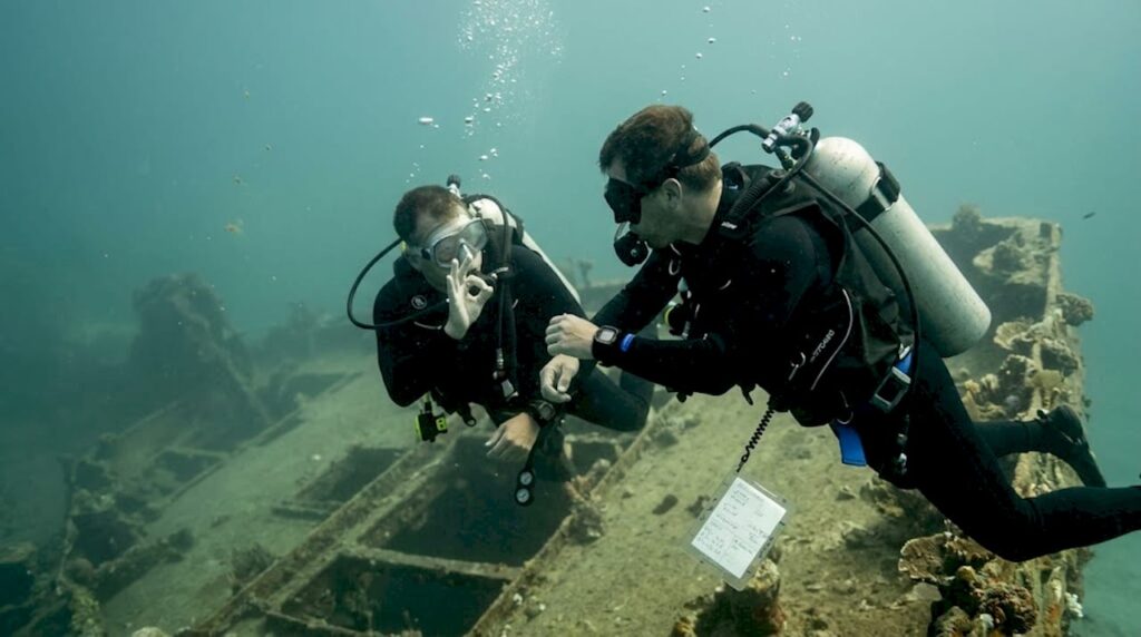 Scuba divers using hand signals underwater