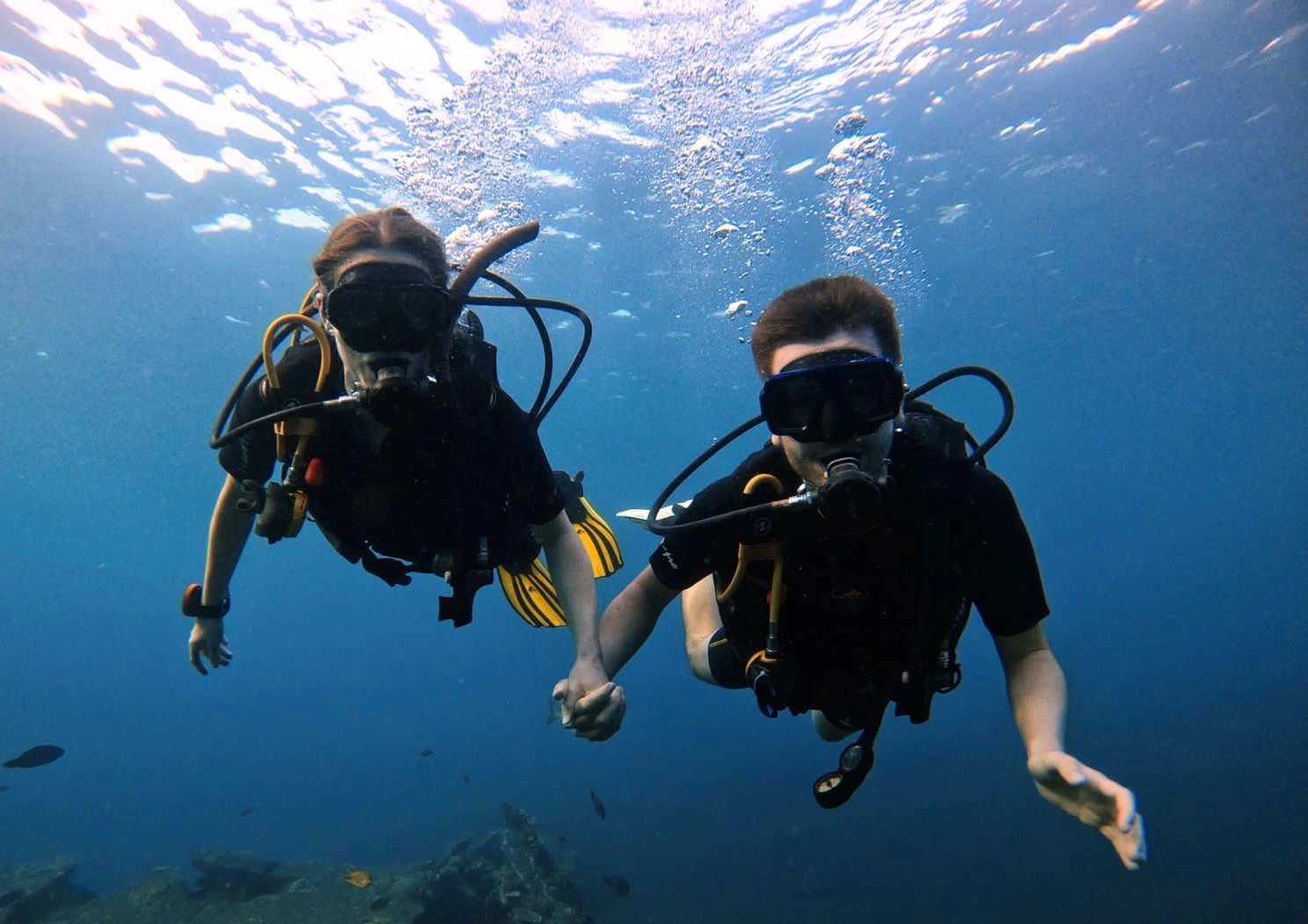 Open Water scuba divers underwater at the USAT Liberty wreck in Tulamben, Bali