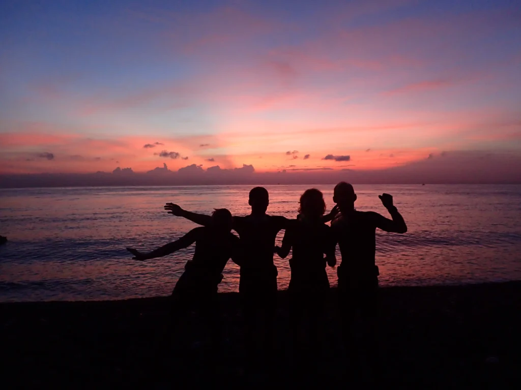 Scuba divers on the shore getting ready for a sunrise dive at the USAT Liberty wreck in Tulamben, Bali